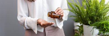 Evde ilaç alan genç bir kadının görüntüsü. Tanınmayan Asyalı kadın elinde haplar ya da vitaminler tutarken sabah ilaçlarını alıyor.