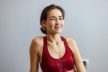 Yoga minderinin üzerinde uzanan çekici bir genç kadının portresi. Orta yaşlı Asyalı bir kadın sağlıklı bir hayat sürüyor. Evinde, modern oturma odasında eğitim görüyor..