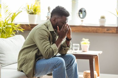 Stres yüzünden başı ağrıyan genç ve yakışıklı bir adam. Migren ağrısı. Baş ağrısı. Genç Afrikalı adam surat asıyor.. 