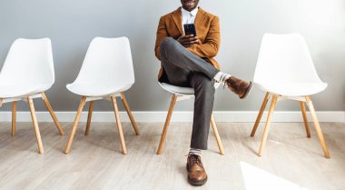 Male candidate waiting for job interview. My device is a great way to keep me busy. The perfect app for a job applicant. Cropped studio shot of a businessman using a smartphone while waiting