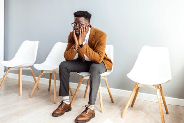 Young worried businessman waiting for job interview. I'm certain I have the right skills for this job. Man waiting or job interview