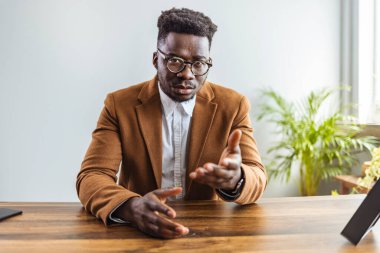 Afro-Amerikan iş adamı kameraya işaret ediyor.