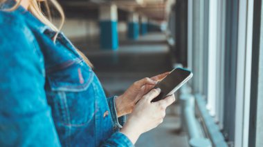 Park yerinde akıllı telefon kullanan genç bir kadının görüntüsünü kapat. 