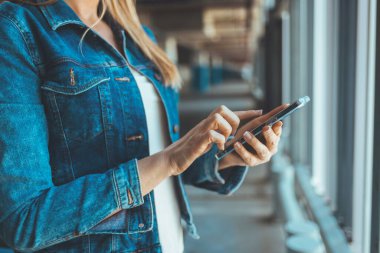 close up view of young woman using smartphone on parking lot 