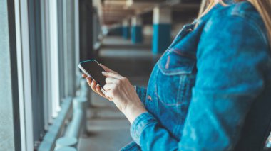 close up view of young woman using smartphone on parking lot 