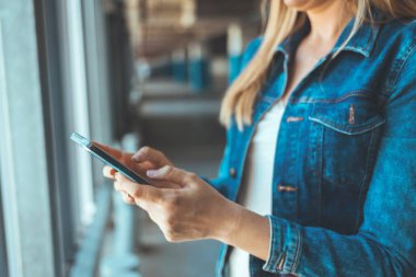 close up view of young woman using smartphone on parking lot 