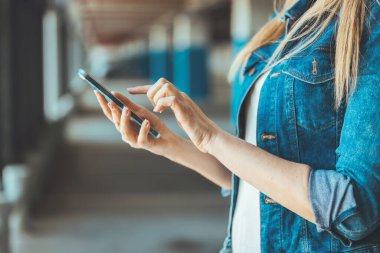 Park yerinde akıllı telefon kullanan genç bir kadının görüntüsünü kapat. 