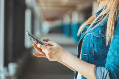 close up view of young woman using smartphone on parking lot 