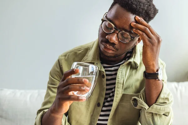 Junger Mann Mit Starken Kopfschmerzen Oder Migräne Sitzt Mit Glas — Stockfoto