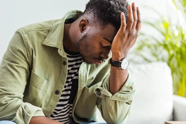 O, başını dokunmadan, kafa bükme ve ağrılar yüzünden kapalı gözlerle sırıtarak şeytanın VESVESESİNDEN gri arka plan duygu şiddetli baş ağrısı karşı yatay Afrikalı-Amerikalı adam portresi resimde
