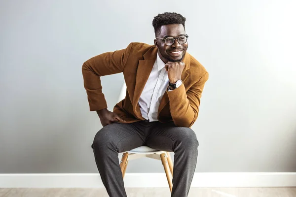 Junger Afrikanisch Amerikanischer Mann Sitzt Auf Stuhl Mit Hand Kinn — Stockfoto