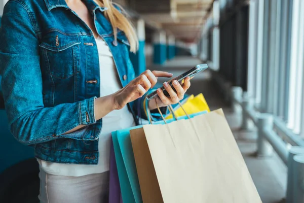 Wanita Muda Dengan Tas Belanja Menggunakan Smartphone — Stok Foto