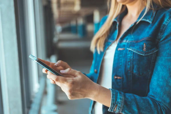 Park yerinde akıllı telefon kullanan genç bir kadının görüntüsünü kapat. 