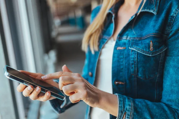 Park yerinde akıllı telefon kullanan genç bir kadının görüntüsünü kapat. 