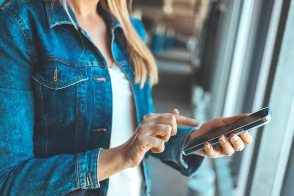 Park yerinde akıllı telefon kullanan genç bir kadının görüntüsünü kapat. 