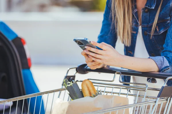 Young Woman Shopping Cart Smartphone Standing Car — Fotografia de Stock