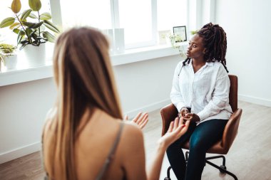 Psychology, depression. Sad, suffering asian young woman, consulting with psychologist, psychiatrist while patient counseling mental problem with doctor at clinic. Encouraging, therapy, health care.