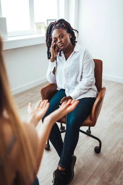 Stresli siyahi kadın hasta danışmanlık psikoloğu, seçici odaklanma. Psikiyatrist, üzgün Afrikalı Amerikalı kadına sinir problemleri konusunda yardım ediyor, seans sırasında not alıyor.