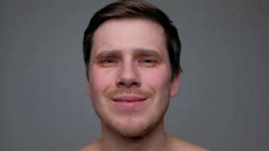 Siyah arka planda izole edilmiş kameraya bakan yakışıklı adam..