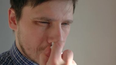 Adam burnuna ilaç sıçratıyor. Burun spreyi, yakın plan.