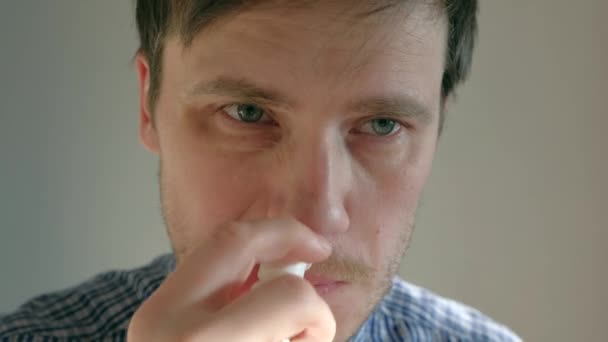 O homem espirra um remédio no nariz escorrendo. pulverização nasal, close-up — Vídeo de Stock