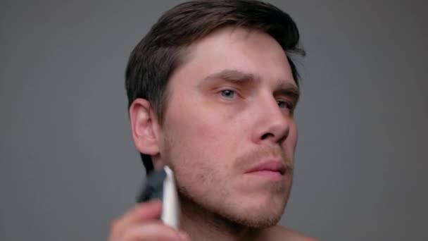Férfi borotválkozás elektromos borotvával. — Stock videók