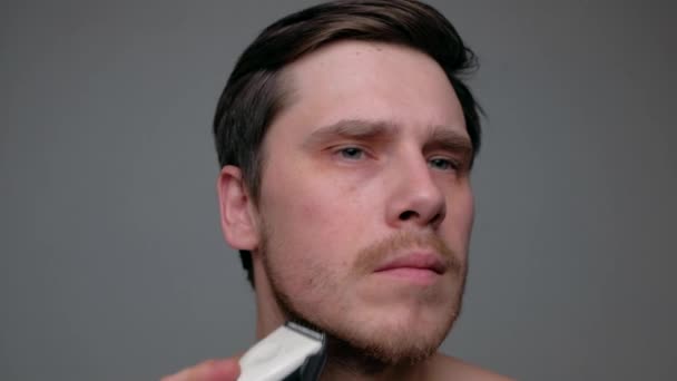 Человек бреется с электрической бритвой. — стоковое видео