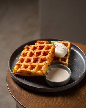 Haşlanmış yumurta ve soslu Belçika peynirli waffle 'ları.