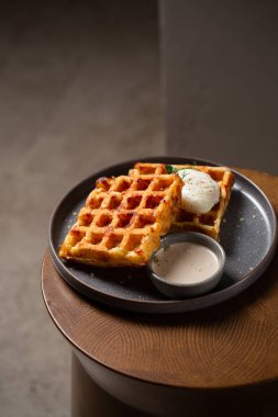 Haşlanmış yumurta ve soslu Belçika peynirli waffle 'ları.