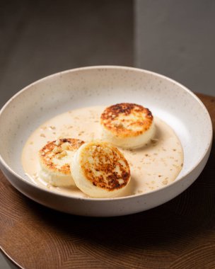 Süzme peynirli krep ya da karamel soslu ve fındıklı şurup. Karamsar ve karamsar sağlıklı kahvaltıyı hesaba kat. Makro ve seçici odak resmi.