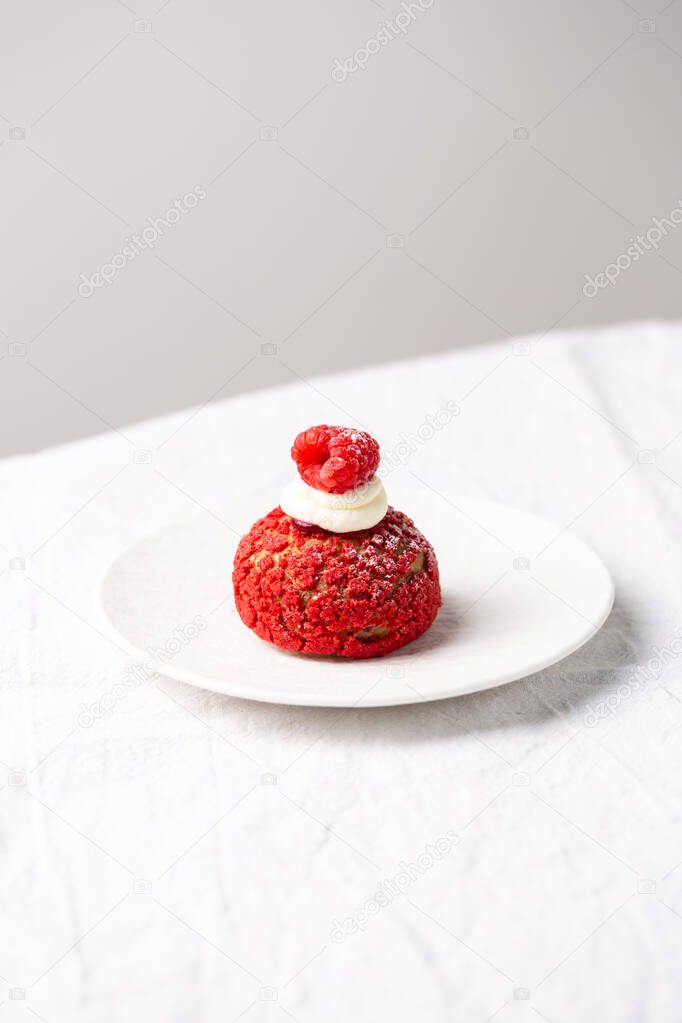 Modern sweet puffs - French choux pastry (eclairs) with vanilla cream and raspberries
