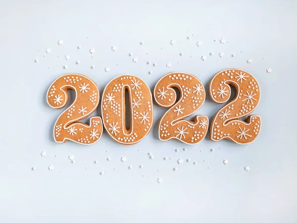 진저브레드 쿠키는 숫자의 형태로 푸른색 배경에 새빨간 2022를 표시합니다 위에서 스톡 사진