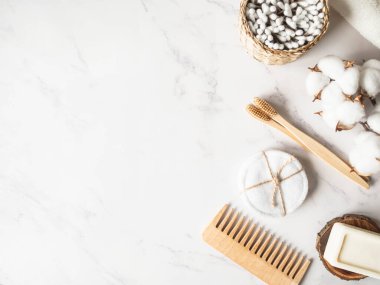 Sıfır atık banyo aksesuarı. Ahşap fırça, sabun, diş fırçası, mermer zeminde pamuk havlu. Bedava plastik konsept. Çevre dostu ev bakımı. Üst Manzara. Boşluğu kopyala