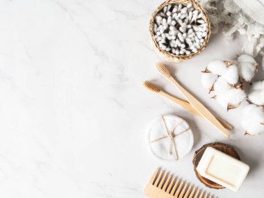 Sıfır atık banyo aksesuarı. Ahşap fırça, sabun, diş fırçası, mermer zeminde pamuk havlu. Bedava plastik konsept. Çevre dostu ev bakımı. Üst Manzara. Boşluğu kopyala