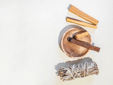 Ruhani temizlik malzemeleri, adaçayı demeti, palo santo tütsü beyaz arka plana yapışıyor. Üst Manzara. Boşluğu kopyala
