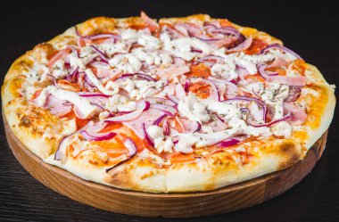 Restoranda ya da mutfak ortamında çeşitli et malzemeleriyle bir pizza turtası manzarası..