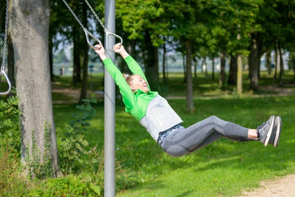 アクティブなライフスタイルのコンセプトで森の公園の屋外スポーツ施設でリングで運動健康的なスポーティ女性をフィット — ストック写真