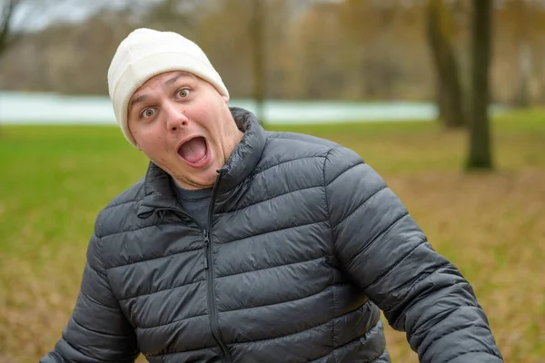 Bere Takmış Kışlık Ceketli Dışarıdaki Parkta Kameraya Dilini Uzatan Oyuncu — Stok fotoğraf