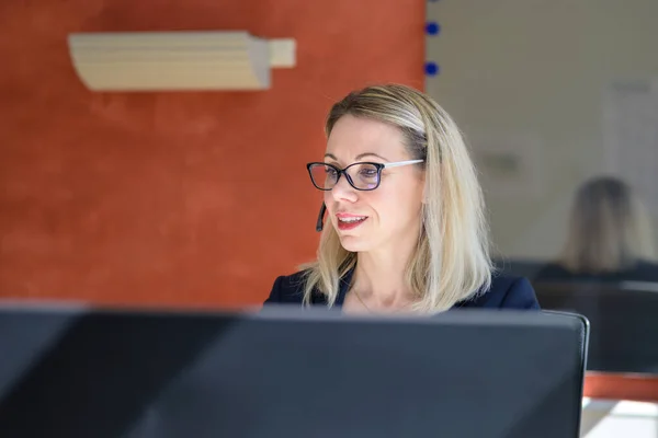 Mulher Negócios Usando Fone Ouvido Sentado Trabalhando Computador Portátil Com — Fotografia de Stock