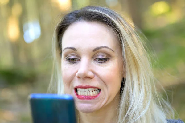 Mulher Loira Atraente Examinando Seus Dentes Espelho Mão Livre Tiro — Fotografia de Stock