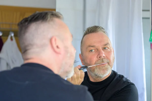 Homem Aparando Sua Barba Com Par Tesouras Uma Vista Sobre — Fotografia de Stock