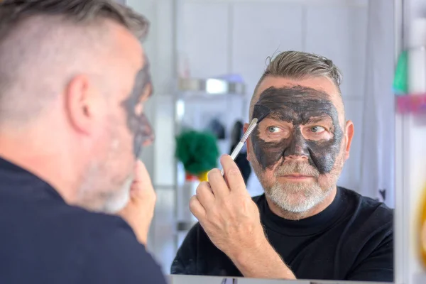Älterer Mann Der Eine Reinigende Und Feuchtigkeitsspendende Kosmetische Gesichtsmaske Einem — Stockfoto