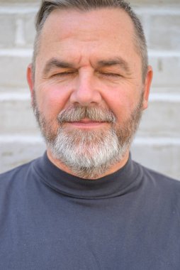 Son sınıf öğrencisi, kapalı gözlerle rahatlamak için bir dakikasını ayırıyor ve yakın plan bir portrede serin bir ifade sergiliyor.