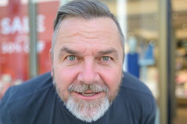 Son sınıf öğrencisi öne eğilip kameraya yoğun bir ifadeyle bakıyor.