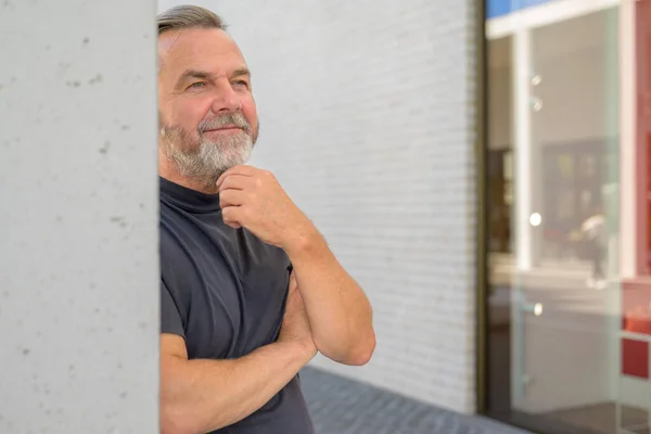 Thoughtful Man Leaning Wall Quiet Smile Strokes His Greying Beard — Fotografia de Stock