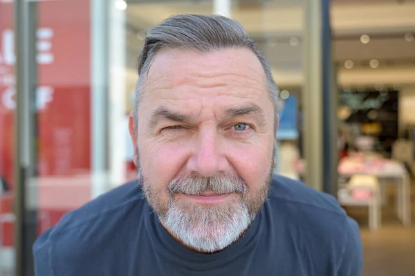 Senior Man Greying Beard Leaning Forwards Winking Camera Head Shoulders — Fotografia de Stock