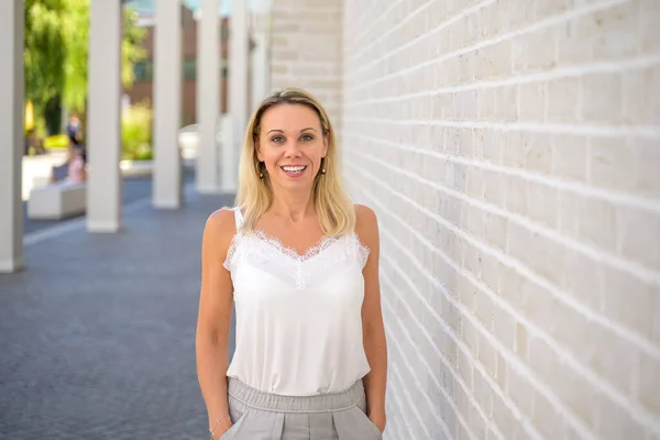 Relaxed Friendly Blond Woman Standing Portico Giving Camera Beaming Smile — Stockfoto