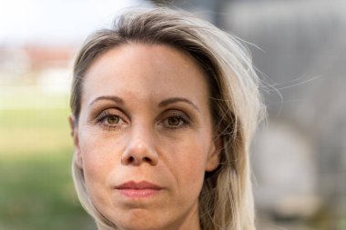 Yüzünde güçlü bir ifade olan güzel bir kadına yaklaş.