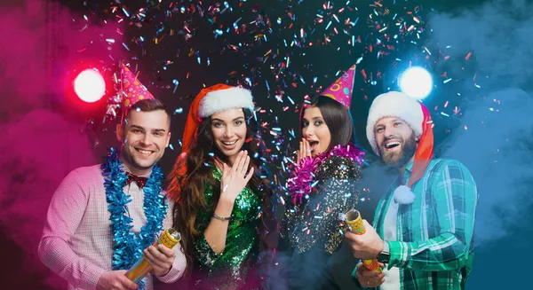 Parti Poppers. En iyi arkadaşların yeni yıl partisi. Yeni yıl ve doğum günü şapkası takan bir grup genç.