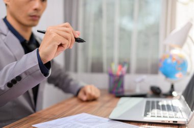 Bir masanın önünde dizüstü bilgisayarın önünde çalışan bir iş adamı.